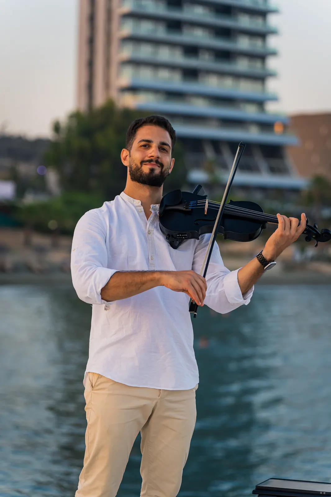 Marios playing an electric violin at golden hour