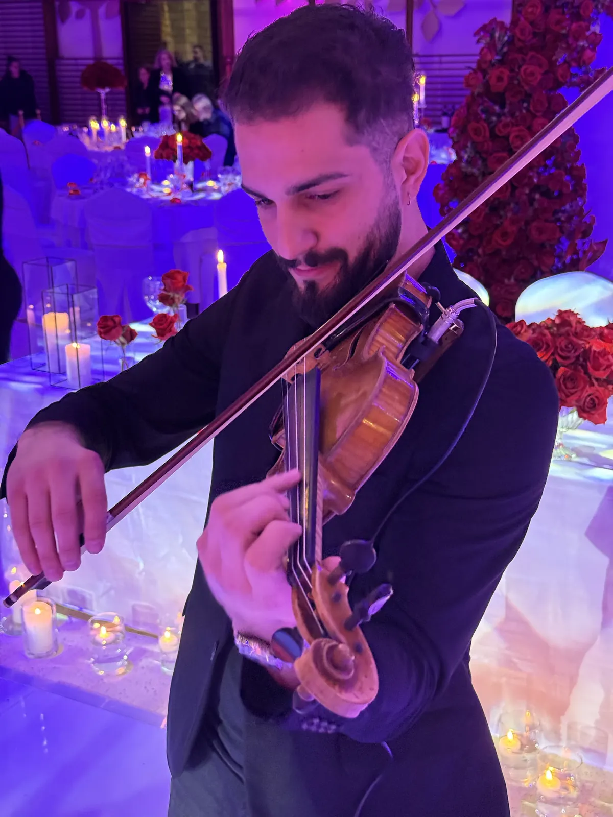 Close portrait of Marios playing at a candlelit reception