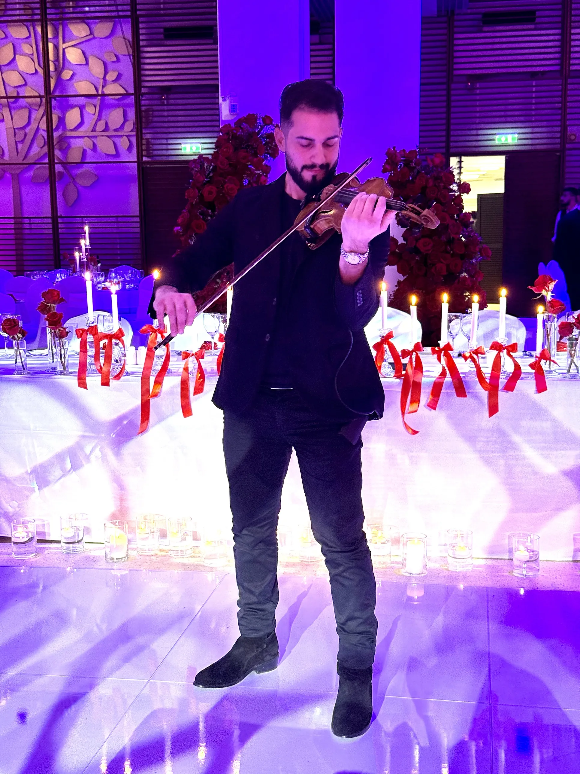 Marios playing violin at a candlelit reception